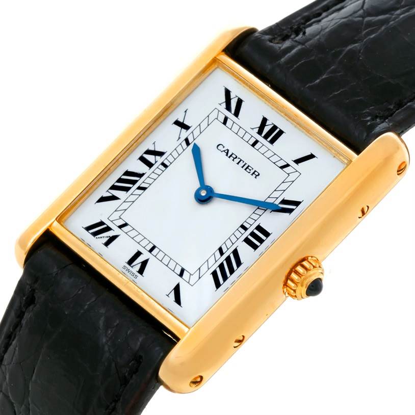 This image shows a Cartier Tank Classic Yellow Gold White Dial Yellow Gold White Dial watch at an angled side view, highlighting its black strap and gold case with Roman numerals.