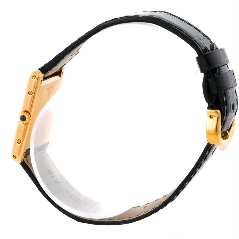 The image shows the side view of a Tank Classic model by Cartier, highlighting its gold case, crown, and black leather strap.