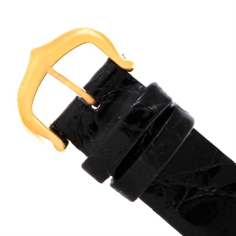 This image shows a close-up view of the black leather strap and gold buckle of the Cartier Tank Classic Women's Yellow Gold White Dial Women's Yellow Gold White Dial watch.