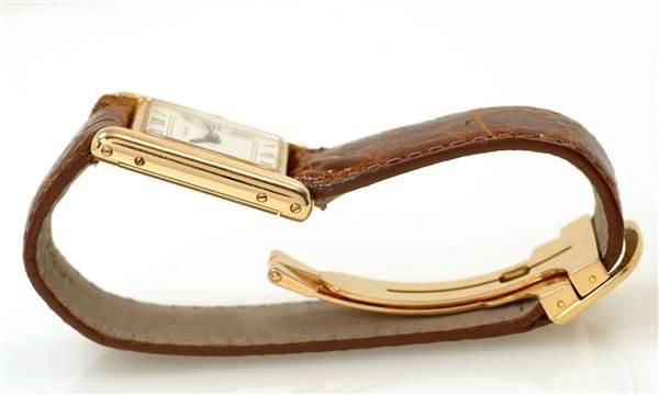 The image shows a Cartier Tank Classic Women's Yellow Gold White Dial Women's Yellow Gold White Dial watch from the side, highlighting its strap, clasp, and part of the face and case.