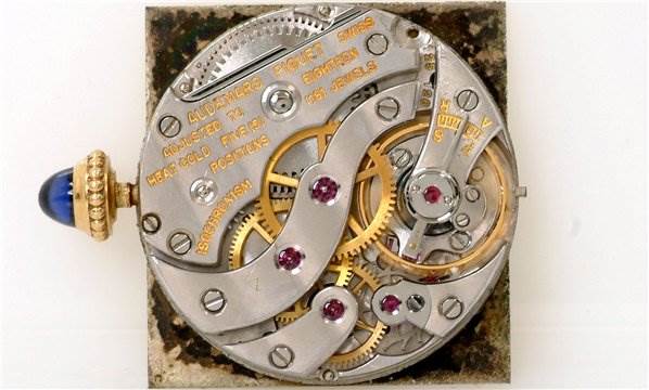 This close-up image shows the intricate inner mechanism of the Cartier Tank Classic Women's Yellow Gold White Dial Women's Yellow Gold White Dial watch.
