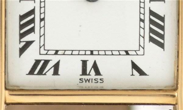 The image shows a close-up of the dial of a Cartier Tank Classic Women's Yellow Gold White Dial Women's Yellow Gold White Dial watch, focusing on the lower part with Roman numerals and the "Swiss" label.