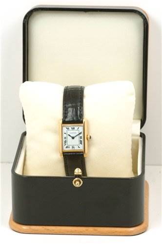 The Cartier Tank Classic Women's Yellow Gold White Dial Women's Yellow Gold White Dial watch is shown from the front, placed inside its open box with a pillow cushion.