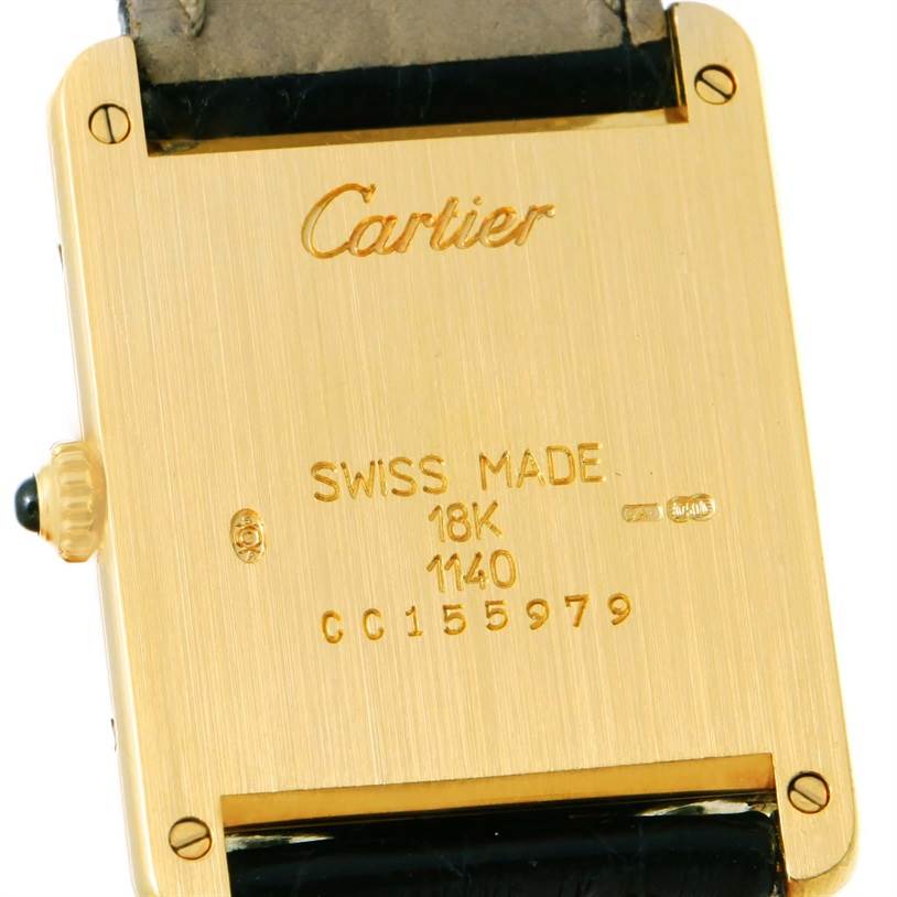 The image shows the back case of a Tank Classic model by Cartier, highlighting inscriptions and the crown on the side.