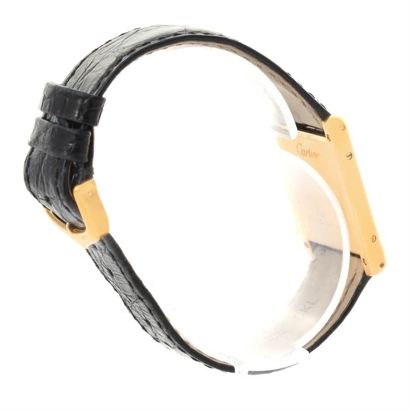 This image shows a side view of a Cartier Tank Classic Yellow Gold White Dial Yellow Gold White Dial watch, highlighting the black leather strap and part of the gold case.