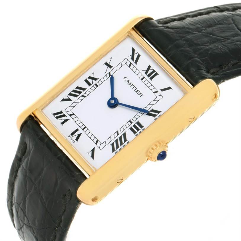 This image shows a Cartier Tank Classic Yellow Gold White Dial Yellow Gold White Dial watch from an angled side view, highlighting its rectangular face, Roman numeral markers, and leather strap.
