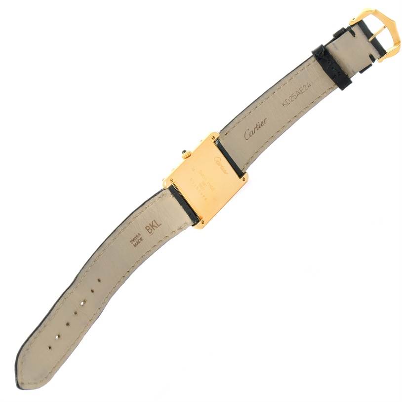 This image shows the back side of the Cartier Tank Classic Yellow Gold White Dial Yellow Gold White Dial watch, highlighting the leather strap and engraved case.