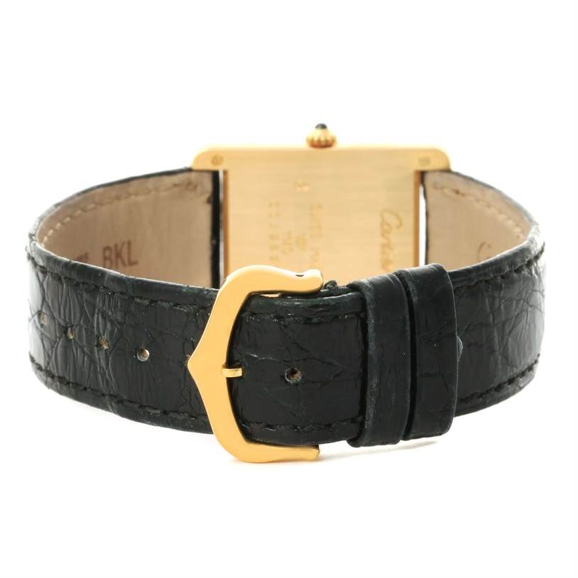 The image shows the back view of the Cartier Tank Classic Yellow Gold White Dial Yellow Gold White Dial watch with its black leather strap and gold buckle.