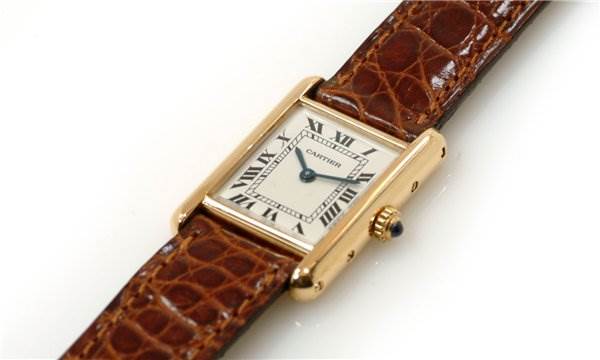 This Cartier Tank Classic Women's Yellow Gold White Dial Women's Yellow Gold White Dial watch is shown at a slight angle, highlighting the face, Roman numerals, and brown leather strap.