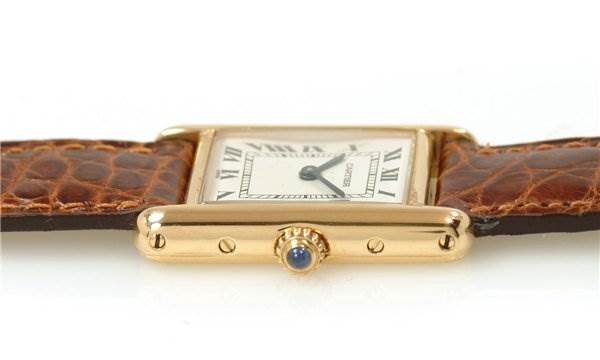 This image shows a side view of the Cartier Tank Classic Women's Yellow Gold White Dial Women's Yellow Gold White Dial watch, highlighting the crown and the brown leather strap.