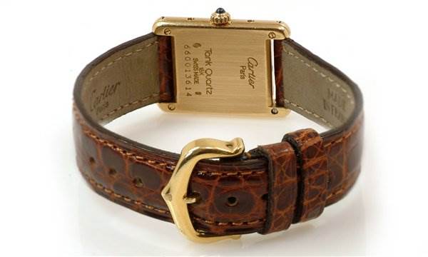The image shows the back and strap of the Tank Classic model by Cartier, highlighting the gold buckle and leather strap.