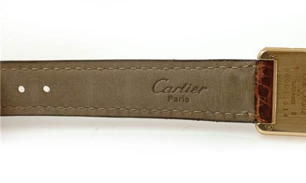 The image shows a close-up of the leather strap and part of the back case of the Cartier Tank Classic Women's Yellow Gold White Dial Women's Yellow Gold White Dial watch.