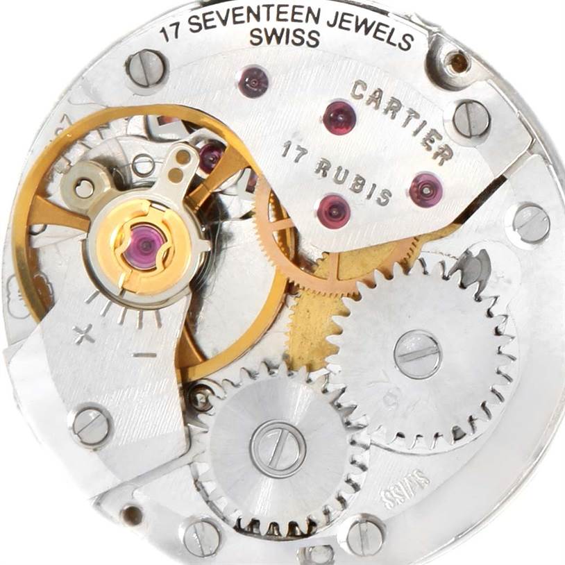 The image shows the inner mechanical movement of a Cartier Tank Classic Women's Yellow Gold White Dial Women's Yellow Gold White Dial watch, highlighting gears and jewels.