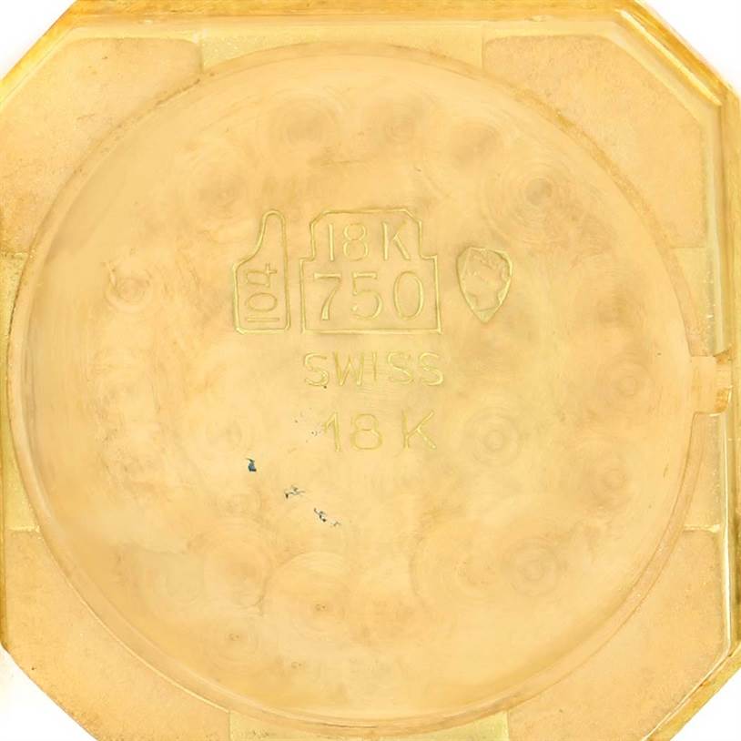 This image shows the inside of the case back of a Cartier Tank Classic Women's Yellow Gold White Dial Women's Yellow Gold White Dial watch, highlighting the 18K gold and Swiss markings.