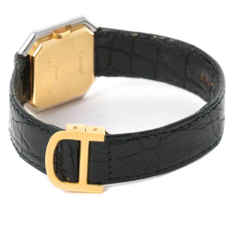 The image shows the back view of a Cartier Tank Classic Women's Yellow Gold White Dial Women's Yellow Gold White Dial watch, highlighting the gold case back, black leather strap, and gold buckle.