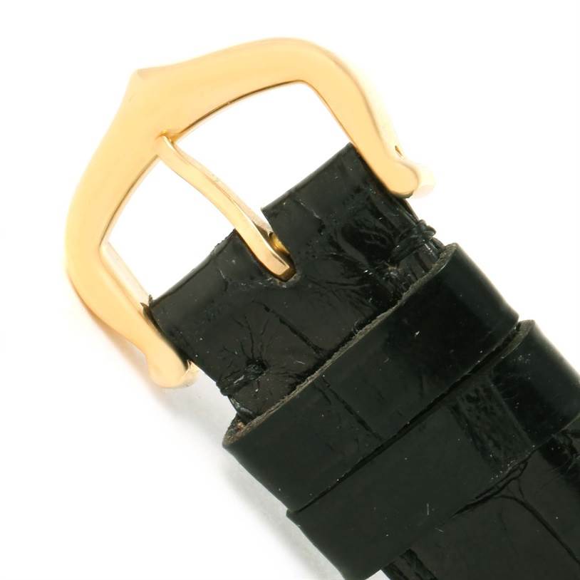 This image shows a close-up of the gold buckle and black leather strap for the Cartier Tank Classic Women's Yellow Gold White Dial Women's Yellow Gold White Dial watch.