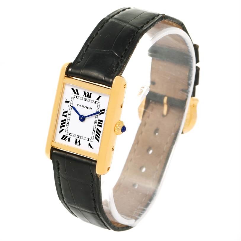 The image shows a Cartier Tank Classic Women's Yellow Gold White Dial Women's Yellow Gold White Dial watch at an angle displaying its face, bezel, crown, and leather strap.