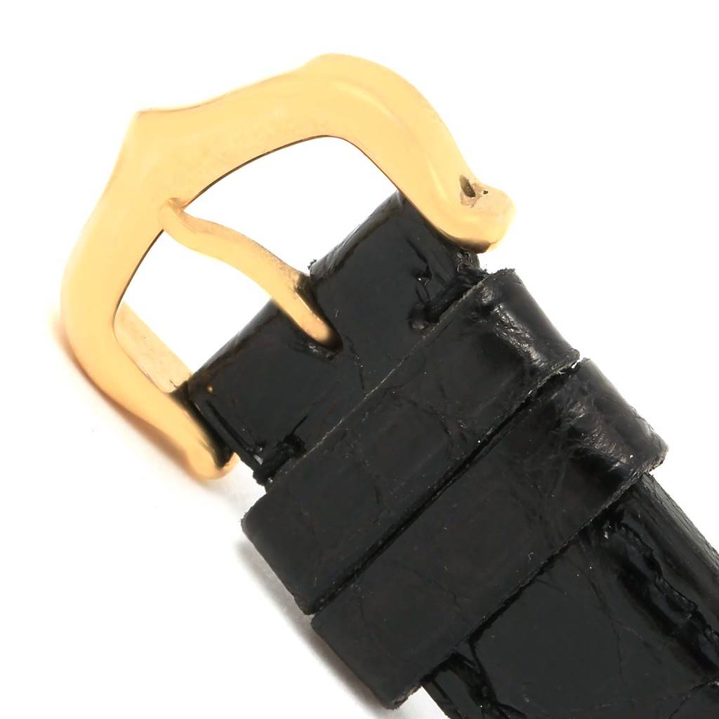 This image shows a close-up of the black leather strap and gold buckle of a Cartier Tank Classic Women's Yellow Gold White Dial Women's Yellow Gold White Dial watch.