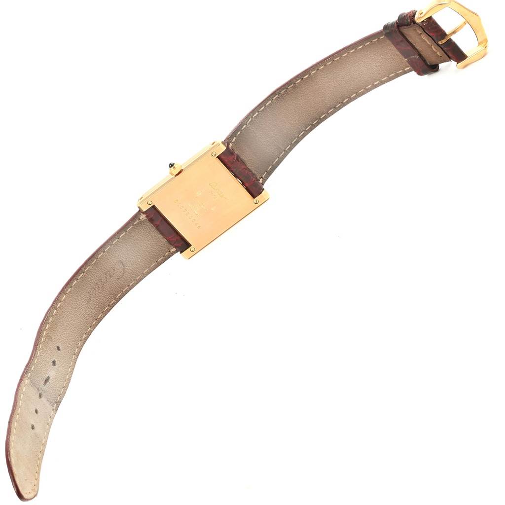 The image shows the back of a Tank Classic model by Cartier, detailing the strap, buckle, and case back.