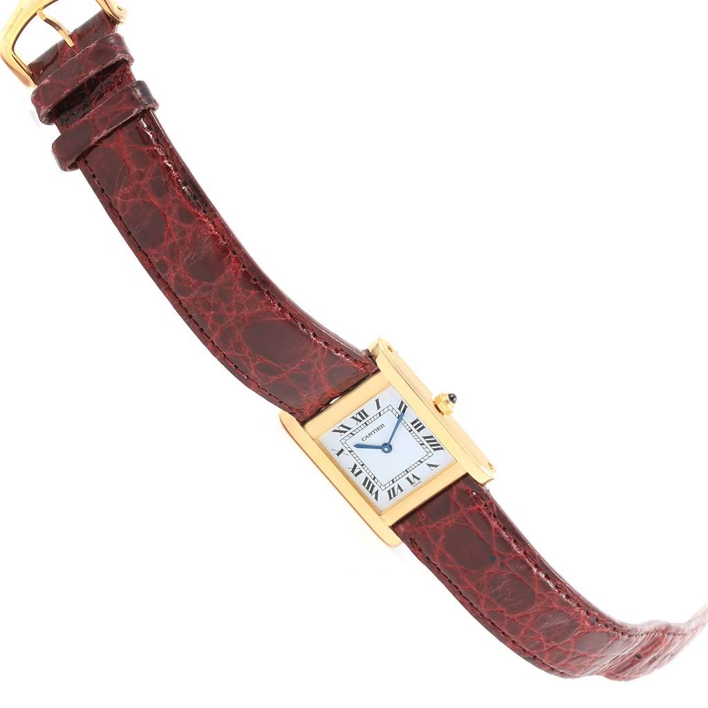 The image shows a Cartier Tank Classic Women's Yellow Gold White Dial Women's Yellow Gold White Dial watch at a slight angle, displaying its gold case, white dial with Roman numerals, and brown leather strap.