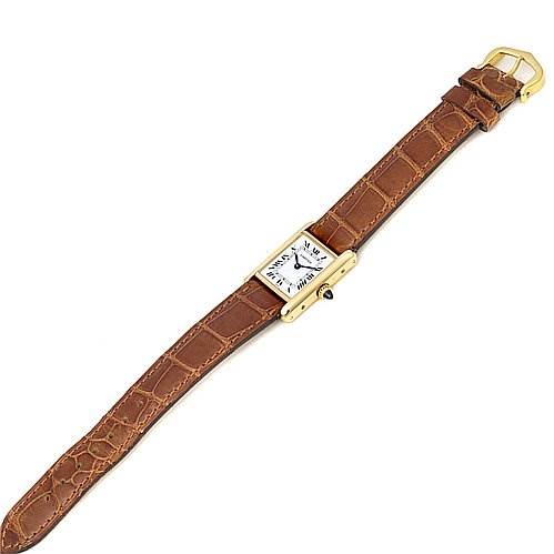 The image shows a top view of a Cartier Tank Classic Women's Yellow Gold White Dial Women's Yellow Gold White Dial watch with a brown leather strap fully extended.