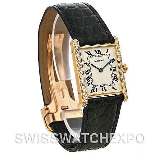 The image shows a Cartier Tank Classic Women's Yellow Gold Silver Dial Women's Yellow Gold Silver Dial watch with a gold case, Roman numeral dial, blue hands, and a black leather strap.