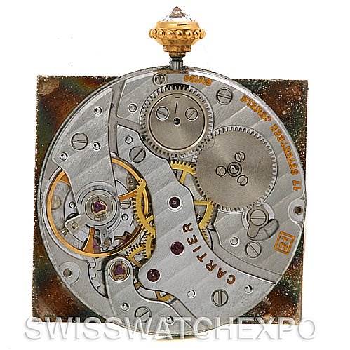 The image shows the intricate internal movement of a Cartier Tank Classic Women's Yellow Gold Silver Dial Women's Yellow Gold Silver Dial watch, highlighting gears and mechanical components.