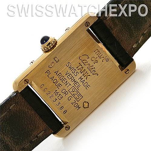 This is a close-up view of the back case of a Cartier Tank Classic Women's Yellow Gold Beige Dial Women's Yellow Gold Beige Dial watch, displaying inscriptions and part of the leather strap.