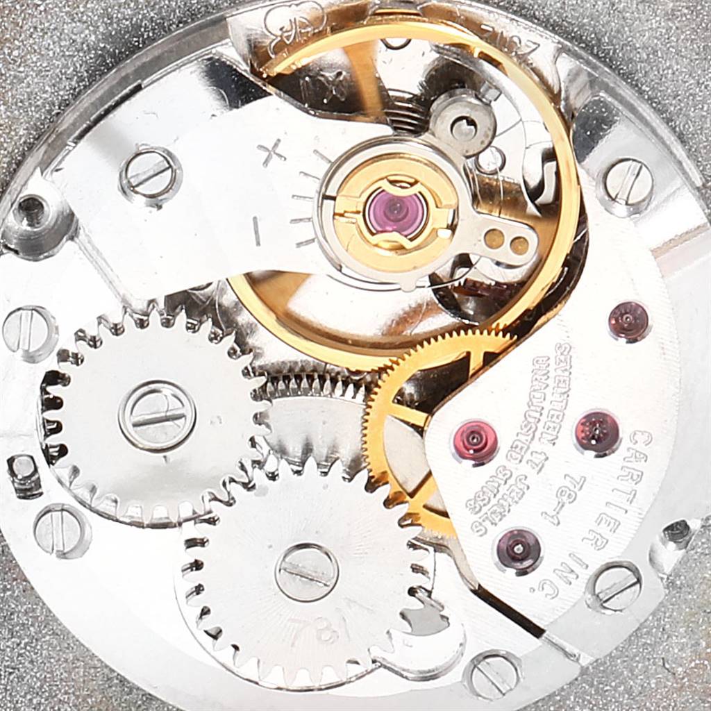 A close-up view of the internal movement mechanism of a Cartier Tank Classic Women's Yellow Gold White Dial Women's Yellow Gold White Dial watch, showing gears and screws.