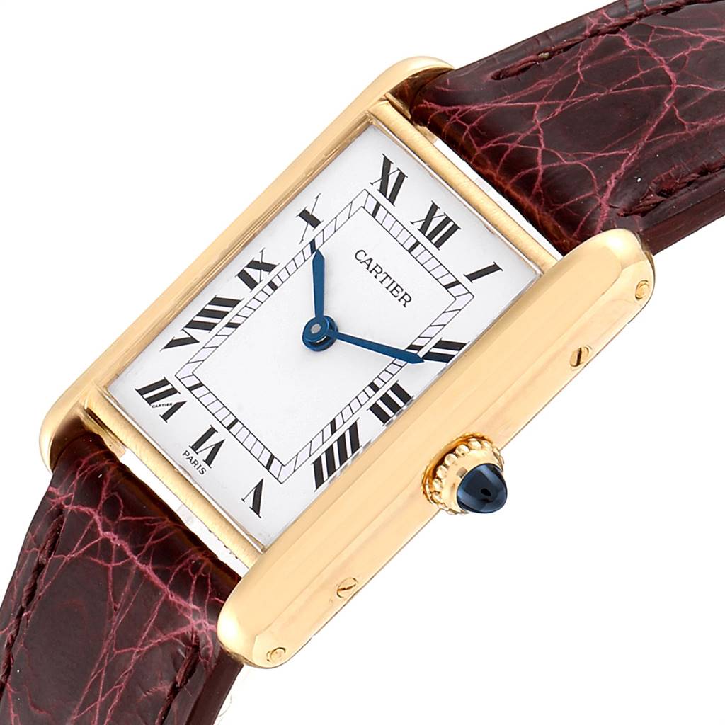 The Cartier Tank Classic Women's Yellow Gold White Dial Women's Yellow Gold White Dial watch is shown at an angle highlighting its rectangular face, Roman numeral markers, and crown with a blue jewel.