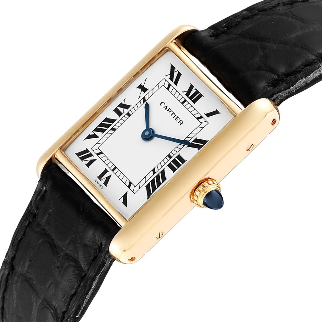 This image shows a close-up angle of a Cartier Tank Classic Women's Yellow Gold White Dial Women's Yellow Gold White Dial watch, highlighting the rectangular face, Roman numeral dial, and crown with a blue cabochon.