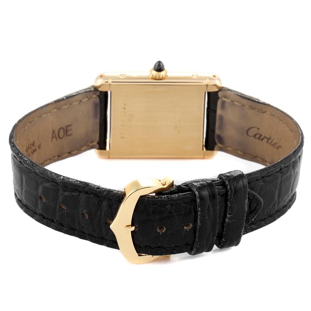 The image shows the back of a Cartier Tank Classic Women's Yellow Gold White Dial Women's Yellow Gold White Dial watch, focused on its black leather strap and gold buckle.