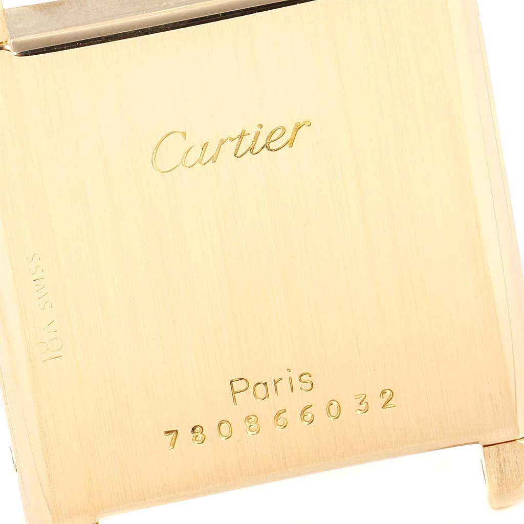 This image shows a close-up of the back case of a Cartier Tank Classic Women's Yellow Gold White Dial Women's Yellow Gold White Dial watch, highlighting the brand name, "Paris," and a serial number.
