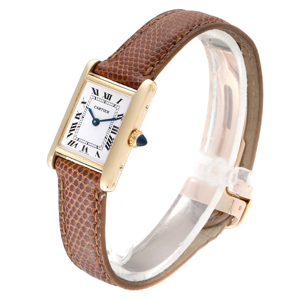 This image shows a Cartier Tank Classic Women's Yellow Gold White Dial Women's Yellow Gold White Dial watch from an angled perspective, featuring the face, crown, and brown leather strap.