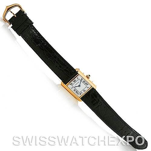 The image shows an overhead view of a Cartier Tank Classic Women's Yellow Gold White Dial Women's Yellow Gold White Dial watch, highlighting its black leather strap and rectangular gold case.