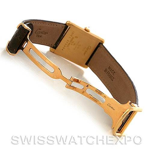 The image shows the underside of a Cartier Tank Classic C70934 Yellow Gold Silver Dial C70934 Yellow Gold Silver Dial watch, highlighting the deployment clasp and leather strap.