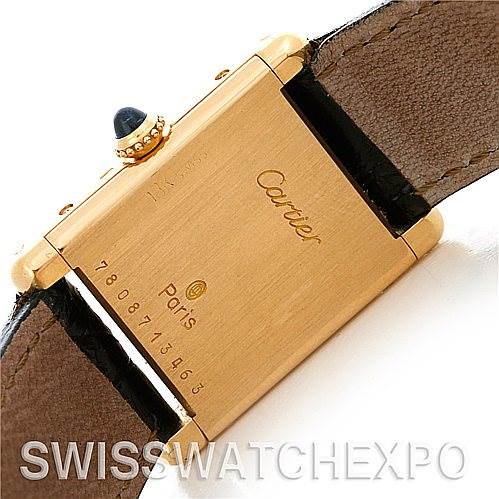 The image shows the back of a Cartier Tank Classic Women's Yellow Gold White Dial Women's Yellow Gold White Dial watch, highlighting the gold-toned case with the brand's name and serial number engraved.