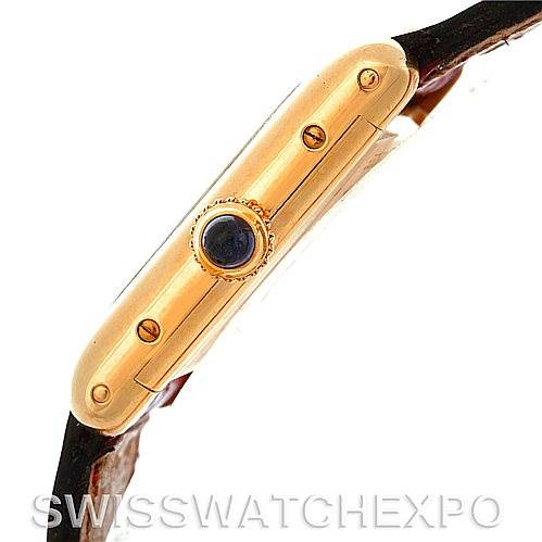 The image displays a side view of the Cartier Tank Classic Women's Yellow Gold White Dial Women's Yellow Gold White Dial watch, showcasing its gold case and winding crown with a blue cabochon.