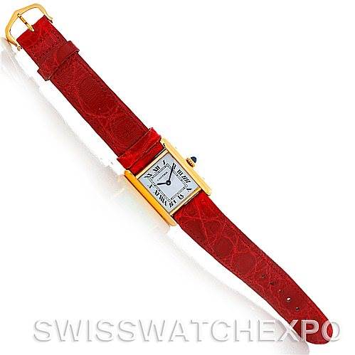 The image shows a Tank Classic model by Cartier from a top-down angle, displaying the entire watch with a red leather strap and a gold rectangular case.