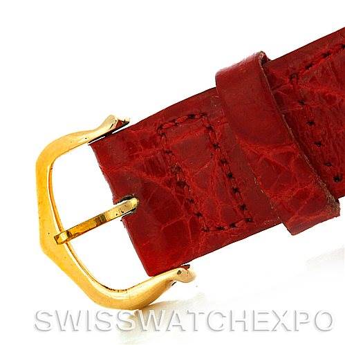 The image shows a close-up of the red leather strap with a gold buckle of a Cartier Tank Classic Women's Yellow Gold White Dial Women's Yellow Gold White Dial watch.