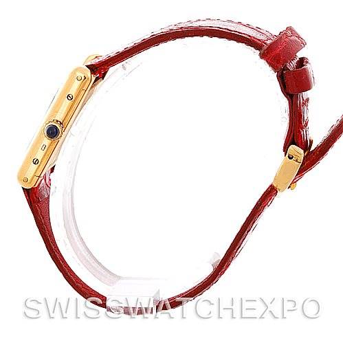 Side view of a Cartier Tank Classic Women's Yellow Gold White Dial Women's Yellow Gold White Dial watch showcasing its gold case, red leather strap, and blue cabochon crown.