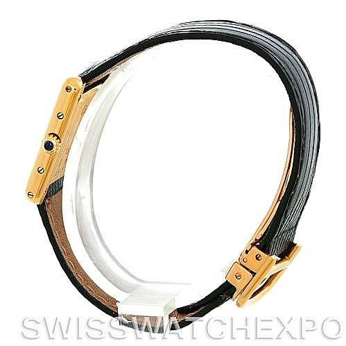 This image shows a side view of the Tank Classic watch by Cartier, highlighting its gold case, crown with a blue gemstone, and black leather strap.