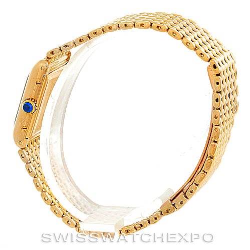 The image shows a side view of the Cartier Tank Classic Women's Yellow Gold Silver Dial Women's Yellow Gold Silver Dial watch, highlighting its gold case, bracelet, and crown with a blue cabochon.