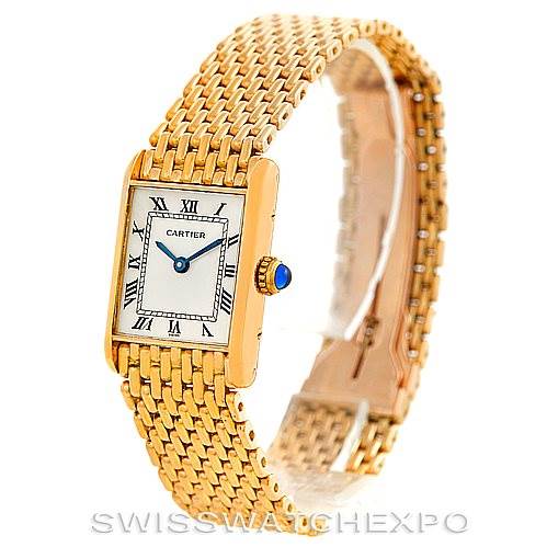 The image shows a Cartier Tank Classic Women's Yellow Gold Silver Dial Women's Yellow Gold Silver Dial watch angled to display its gold case, white dial with Roman numerals, and woven bracelet.