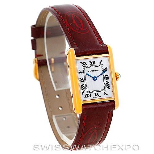 The image shows a Cartier Tank Classic Women's Yellow Gold White Dial Women's Yellow Gold White Dial watch from an oblique angle, highlighting its rectangular face, Roman numeral dial, and red leather strap.