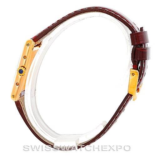 The image shows a side view of a Cartier Tank Classic Women's Yellow Gold White Dial Women's Yellow Gold White Dial watch, displaying its golden case, crown with a blue cabochon, and brown leather strap.