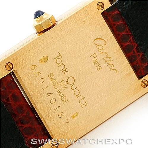 This image shows the back of a Cartier Tank Classic Women's Yellow Gold White Dial Women's Yellow Gold White Dial watch, including the inscription, screws, and part of the strap.
