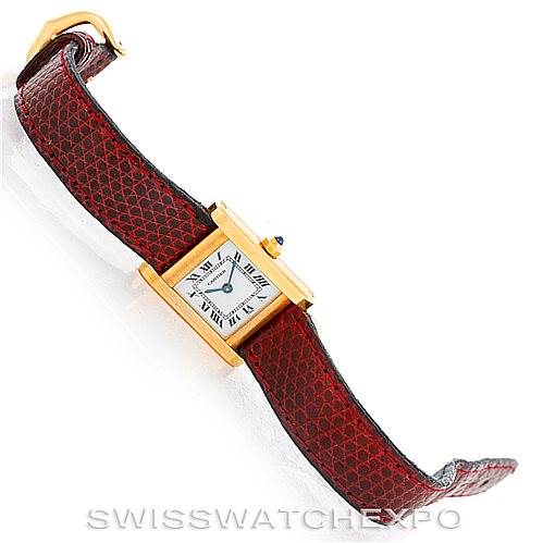 This image shows a Cartier Tank Classic Women's Yellow Gold White Dial Women's Yellow Gold White Dial watch at an oblique angle, highlighting its rectangular dial and red leather strap.