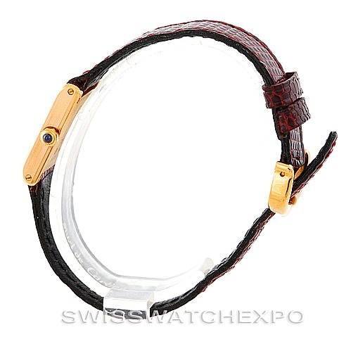 The Cartier Tank Classic Women's Yellow Gold White Dial Women's Yellow Gold White Dial watch is shown from a side angle, revealing its gold case, red leather strap, and buckle clasp.