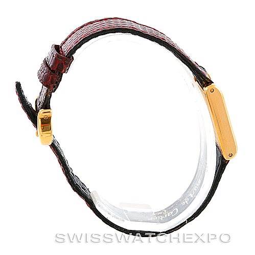 The image shows a side profile of a Cartier Tank Classic Women's Yellow Gold White Dial Women's Yellow Gold White Dial watch, highlighting the gold bezel and dark strap.